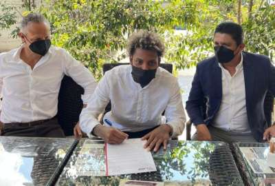 Esteban Paz (izq.) observa a Joao Ortiz firmar el contrato. A la derecha, Jos&eacute; Delgado, presidente del Delf&iacute;n.