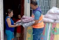 Funcionarios del Servicio Nacional de Gesti&oacute;n de Riesgos entregan ayuda humanitaria a una familia afectada por inundaci&oacute;n en Esmeraldas
