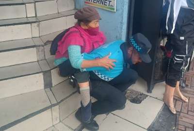 Agente de control de Quito carg&oacute; a una mujer en su espalda