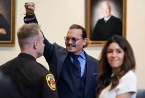Johnny Depp levanta su mano en se&ntilde;al de triunfo, tras el &uacute;ltimo d&iacute;a del juicio