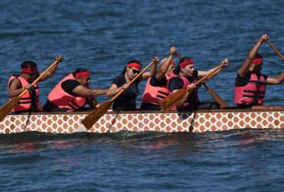 Mujeres sobrevivientes de cáncer de mama participan en la celebración del Día del Bote del Dragón.