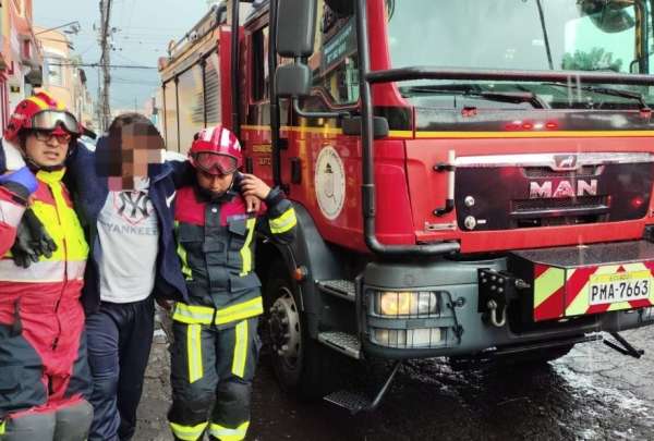 Bomberos asisten a uno de los afectados por la ca&iacute;da de un rayo, al norte de Quito.